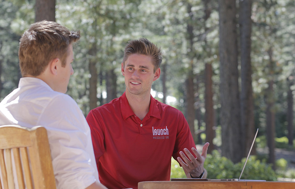 an image of a Launch teacher speaking one-on-one with a student while sitting in chairs outdoors